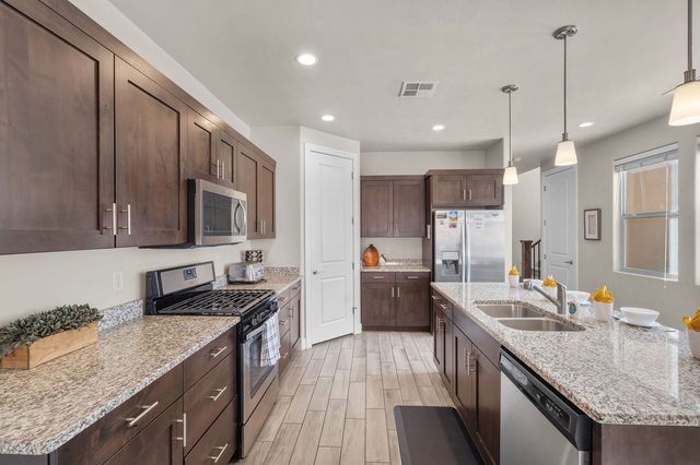 Galley view of the kitchen with sink and refrigerator