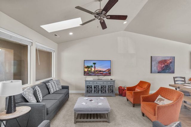 Family room seating with ottoman, skylight and ceiling fan