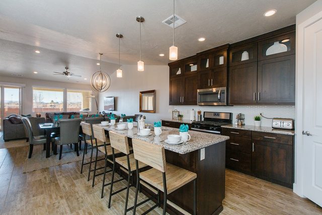 Kitchen island with bar stools opening to the dining and living areas