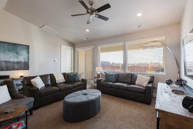 Living room leather sofas, ottoman and large windows