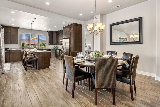 Dining table beside the kitchen island and pendant lights
