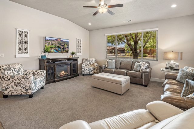 Living room with fireplace TV console and leather sofas