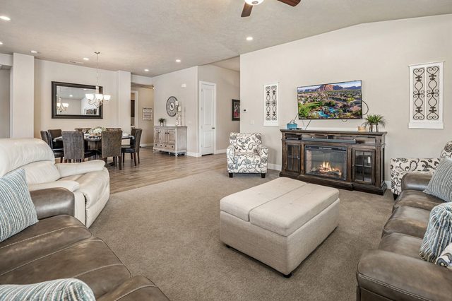 Living room fireplace and TV with dining area behind