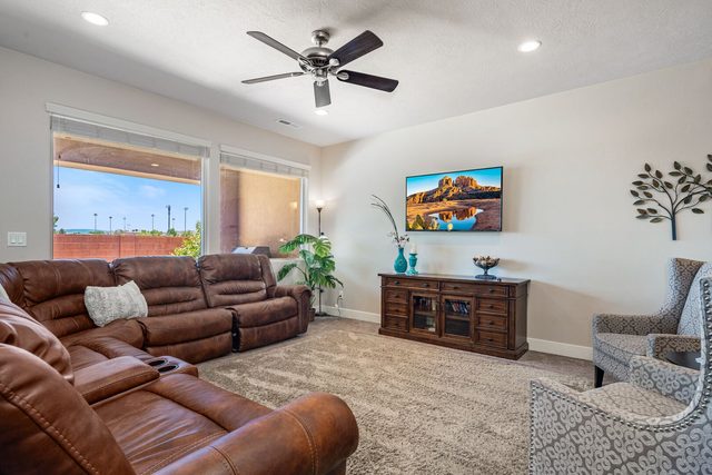 Living room with leather recliners, armchairs and wall TV