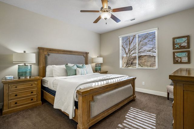 Primary bedroom with king bed and wood frame at Paradise Village 84