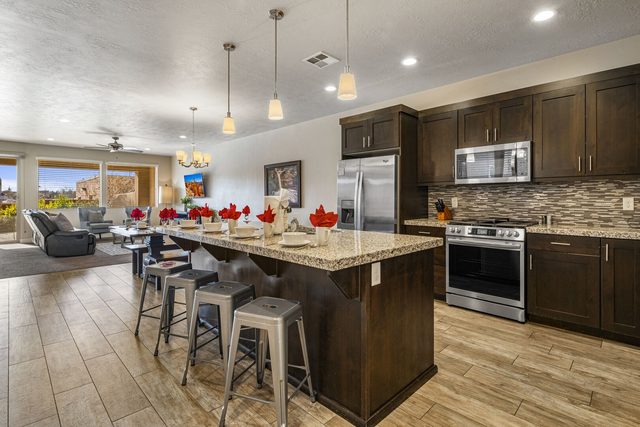 Kitchen island with four bar stools and stainless appliances