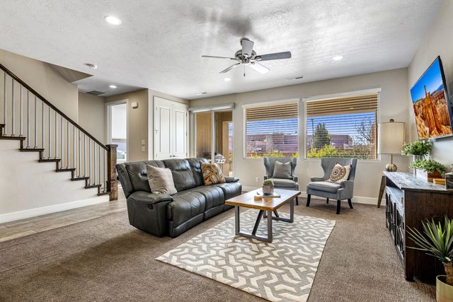 Main living room with leather recliner sofa and staircase