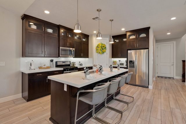 Kitchen with quartz island, bar stools and stainless appliances at Paradise Village 86
