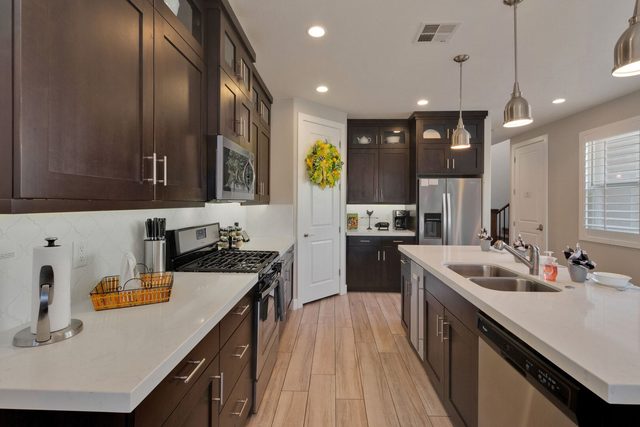 Kitchen with gas range, double sink and dark cabinets