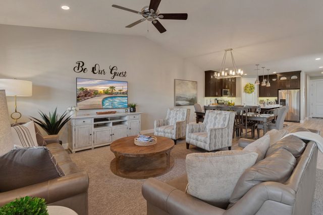 Open living room with round coffee table and dining beyond
