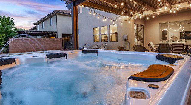Home 94 private hot tub under string lights at dusk