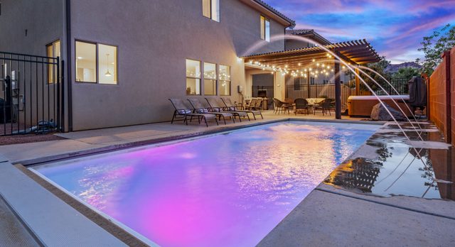Home 94 private backyard pool with water jets at twilight