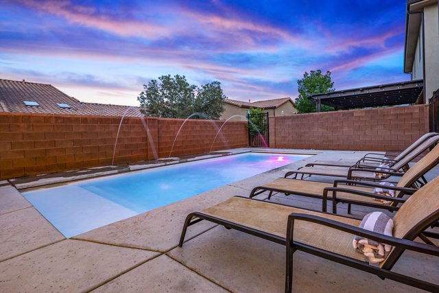Private pool with loungers and water features at sunset