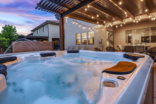 Private hot tub under pergola string lights at Paradise Village 94