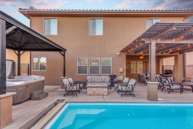 Backyard view of pool, fire pit and hot tub