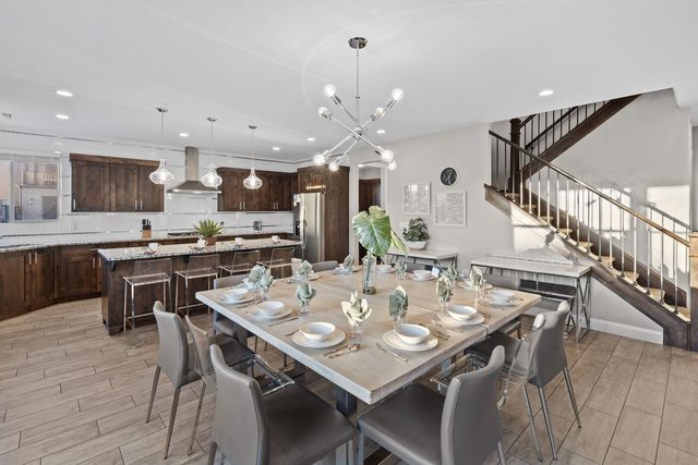 Dining table beside kitchen island and staircase