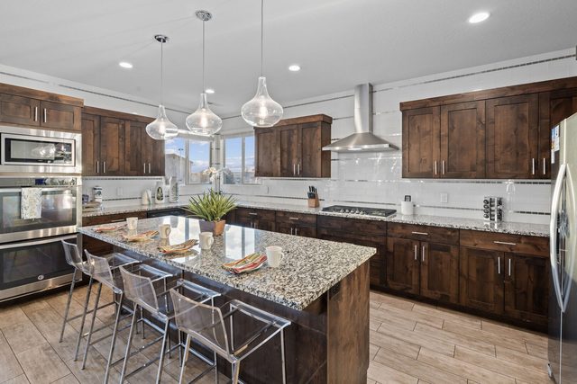 Kitchen with long granite island and bar stools at Paradise Village 97