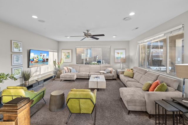 Main living room with sectional, green chairs and TV at Paradise Village 97