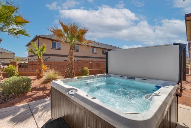 Private hot tub on the backyard patio with palm trees