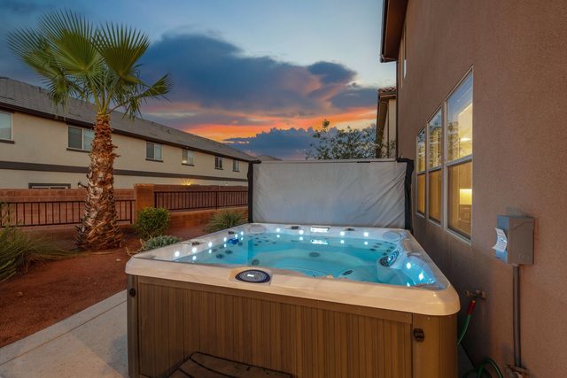 Private hot tub lit at dusk beside Paradise Village 99