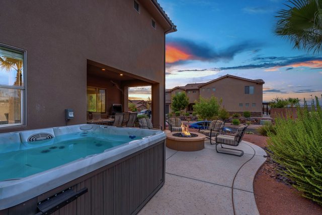 Private hot tub with fire pit and patio at sunset
