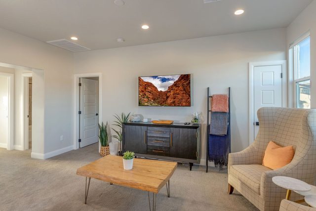 Loft seating area with coffee table and wall TV at Paseos 1101