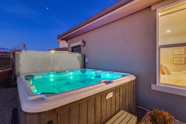 Private hot tub lit up at night beside Paseos 1101