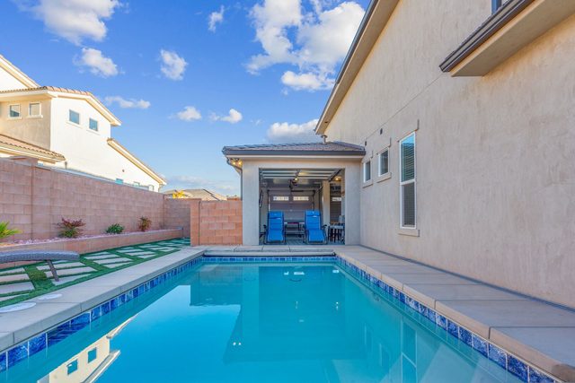 Private backyard pool with tiled edge and pool house at Paseos 1121