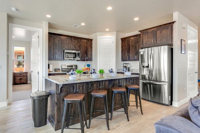 Kitchen island with four bar stools and dark wood cabinets