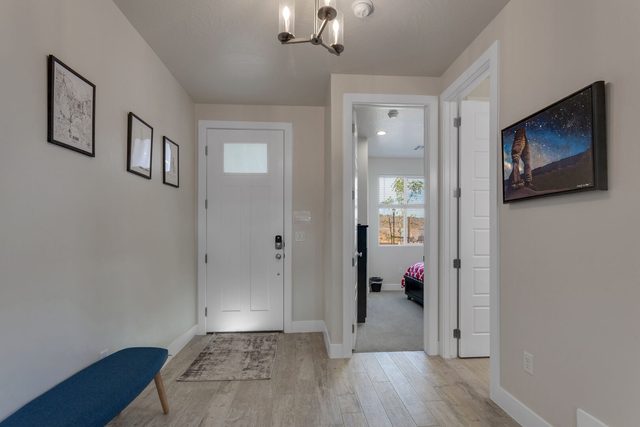 Front entry with bench and hallway to a downstairs bedroom