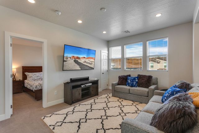 Upstairs loft with sofas, rug and large wall-mounted TV