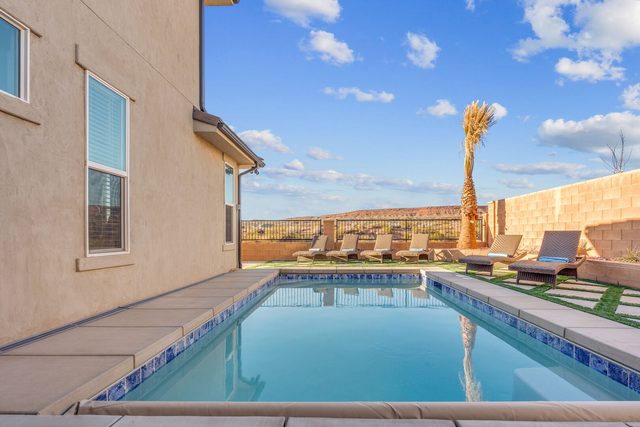 Rectangular private pool with blue tile border and loungers