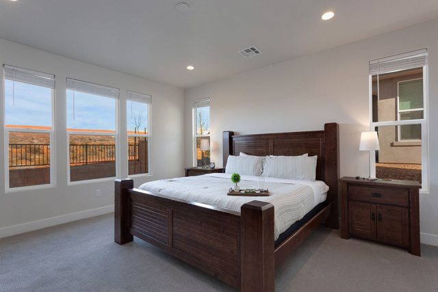 Downstairs king bedroom with dark wood bed and desert view windows