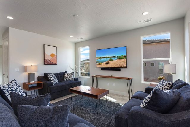 Living room with navy sofas, wood coffee table and wall TV
