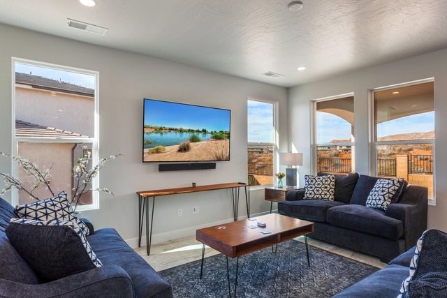 Living room seating facing a large TV with soundbar at Paseos 1129