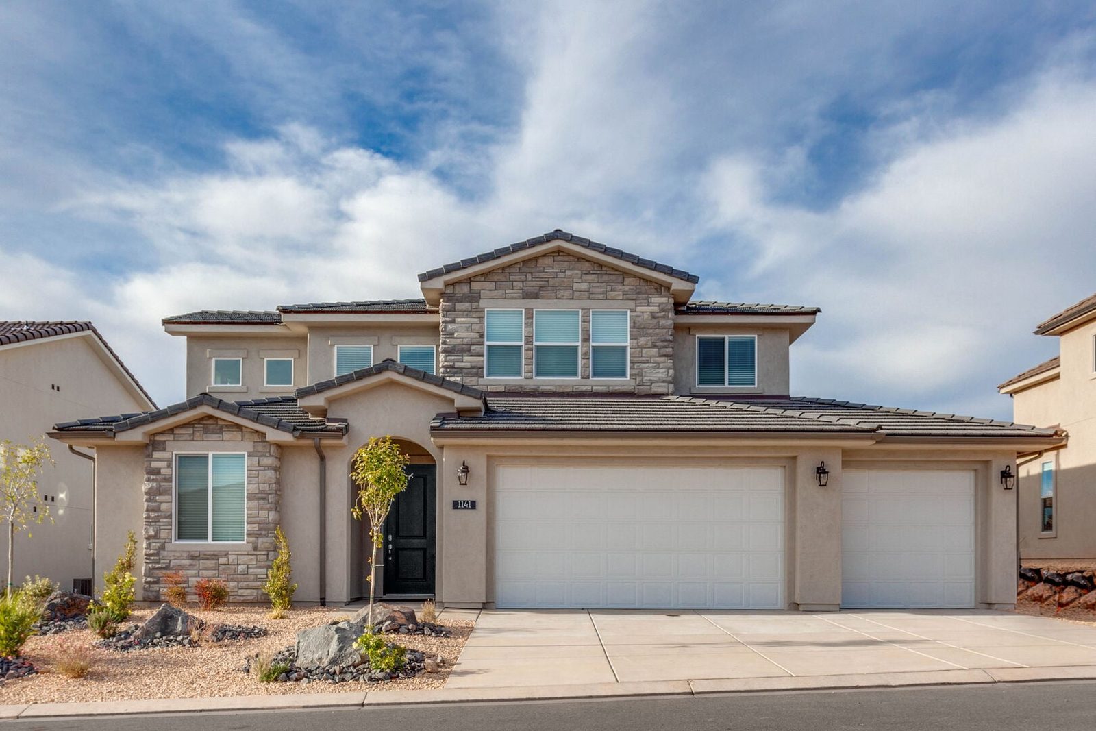 Front of Paseos 1141 with stone accents and three-car garage