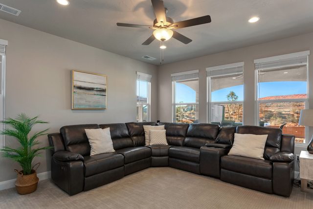 Leather sectional in the living room with ceiling fan