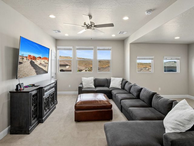 Loft lounge with sectional, leather ottoman and wall TV