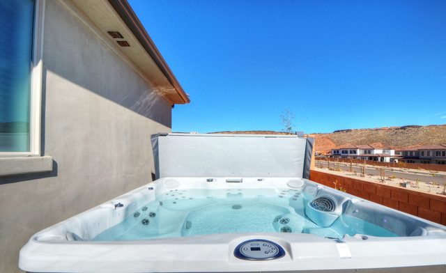 Private hot tub with open cover and desert views