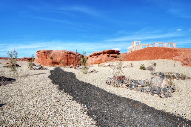 Red rock and desert landscaping view behind the home