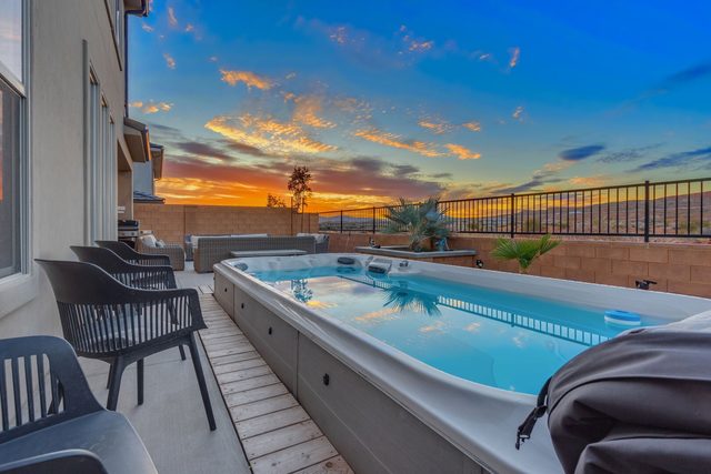 Private swim spa along the fenced backyard at sunset