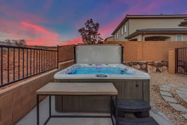 Private hot tub beside the backyard fence at sunset