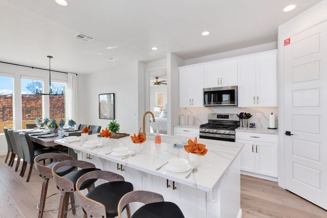 Long quartz kitchen island with bar seating next to the dining area