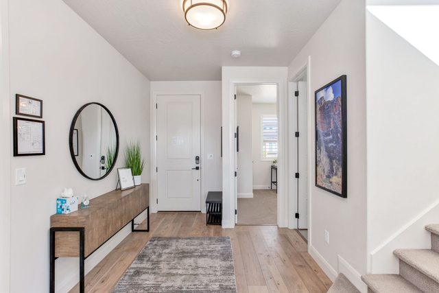 Entry hallway with console table, mirror and stairs to upstairs