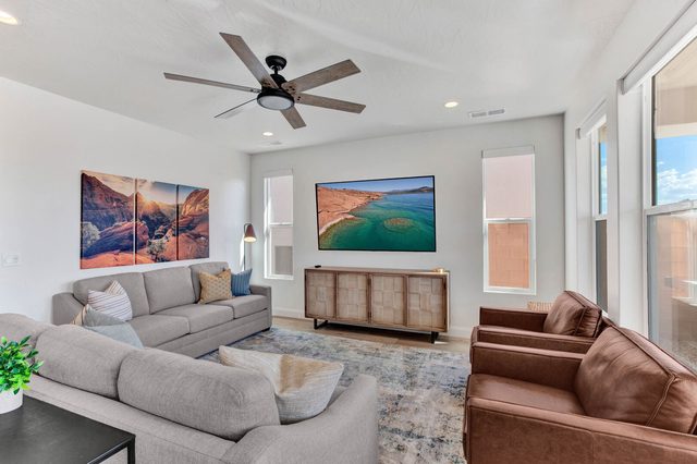 Main living room with sofas, leather chairs and wall-mounted TV