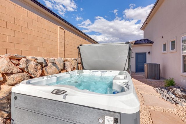 Private hot tub beside the house with red rock landscaping