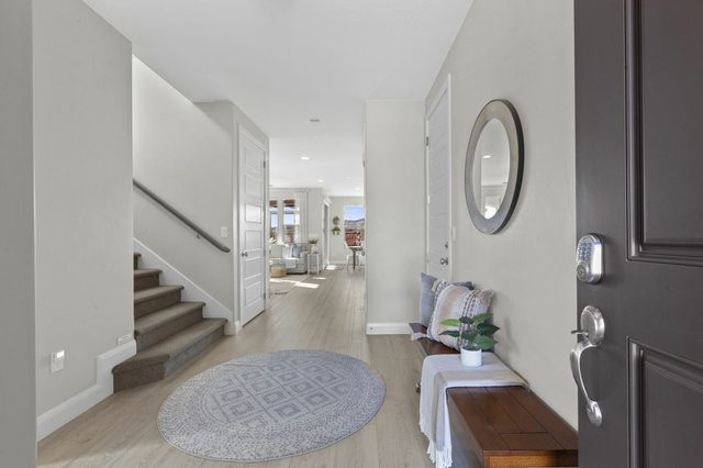 Front entry hall with staircase, bench and round mirror