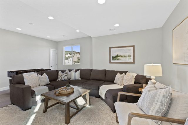 Upstairs loft with large brown sectional and coffee table
