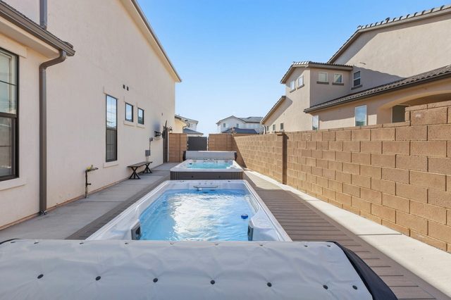Two in-ground swim spas along the side of the house