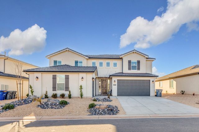 Front of the two-story home with garage and desert landscaping